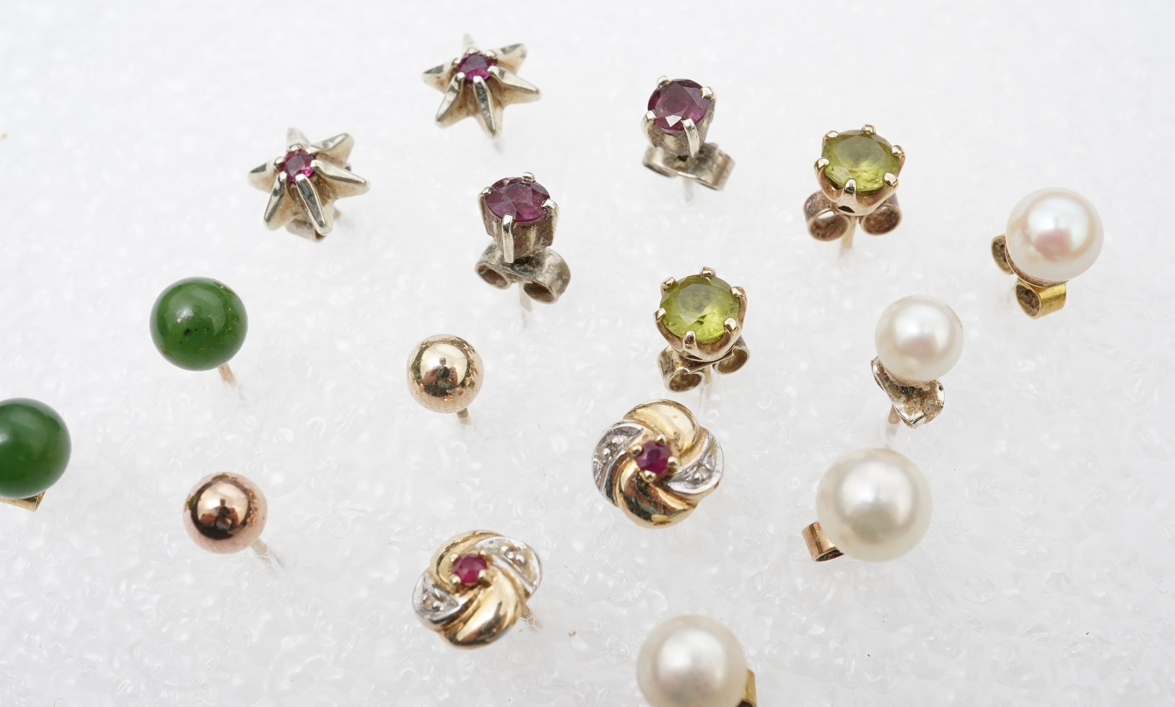 Four assorted pairs of 9ct and gem set ear studs including peridot and cultured pearl, together with three other assorted pairs yellow or white metal ear studs and two odd ear studs.